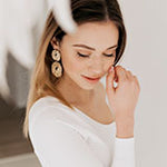 Woman wearing gold drop earrings.