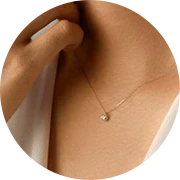 gold necklace with a small, round pendant.